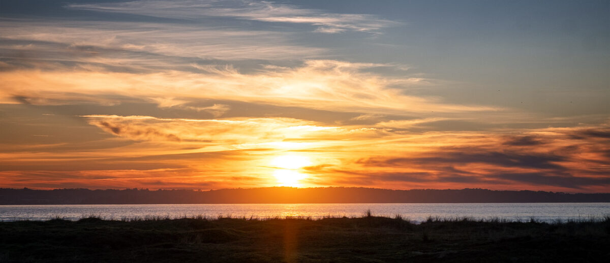 Coucher de soleil flamboyant sur l'océan en Baie de Douarnenez, Finistère.