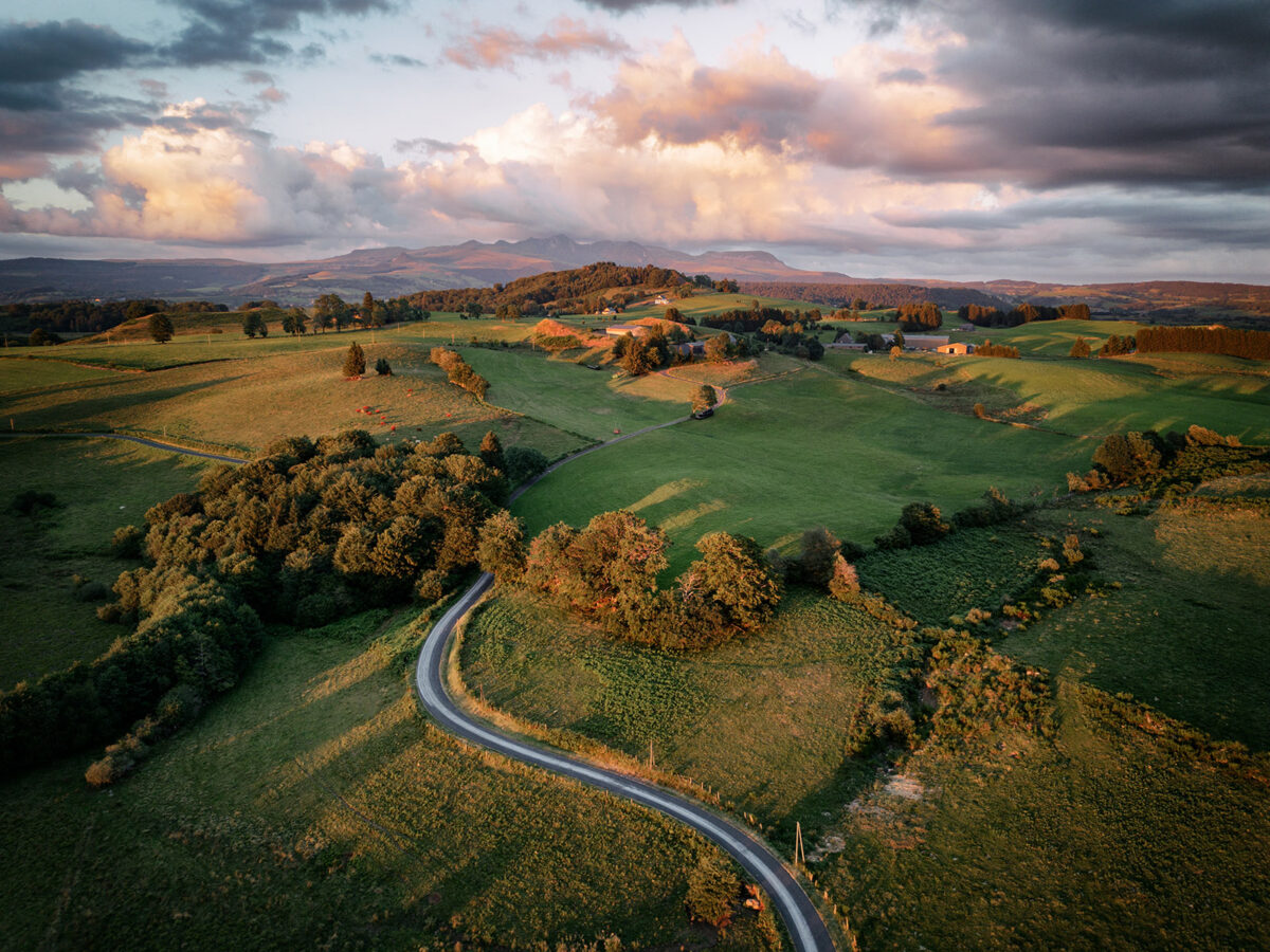 Panorama du Massif du Sancy vu depuis Jouvion à Saint-Donat, montrant les crêtes volcaniques de l'Auvergne dominant les plateaux de l'Artense en été.