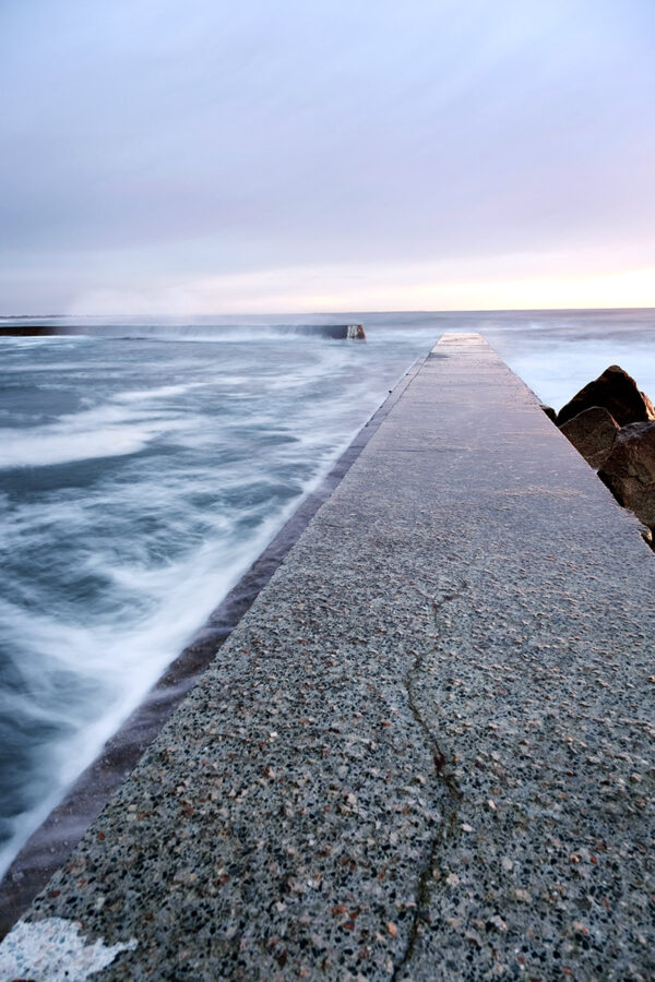 Photo en pose longue plage de Penhors Pouldreuzic, effet de filé sur l'eau et digues de béton